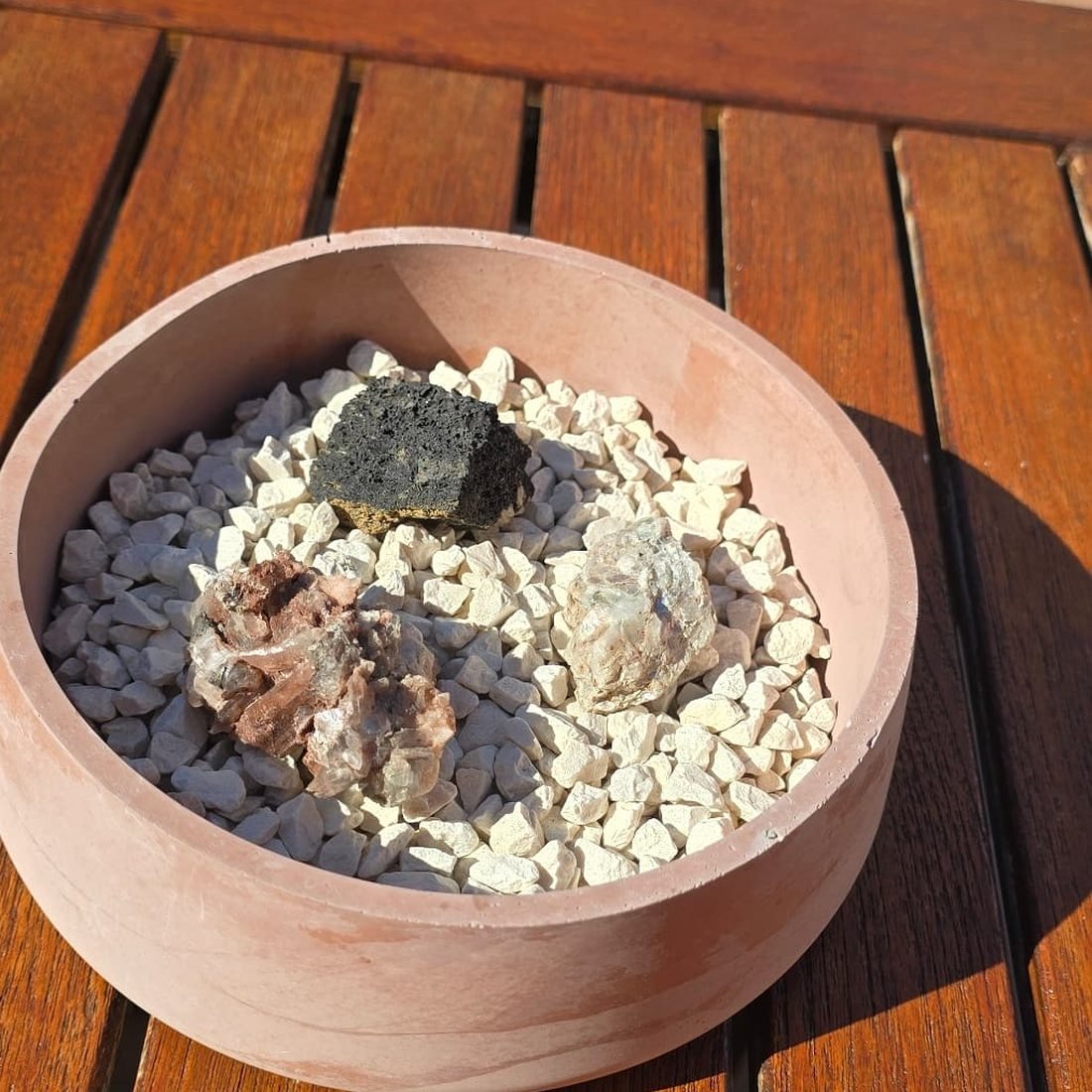Cuenco bajo de cemento terracota con grava blanca y minerales en bruto