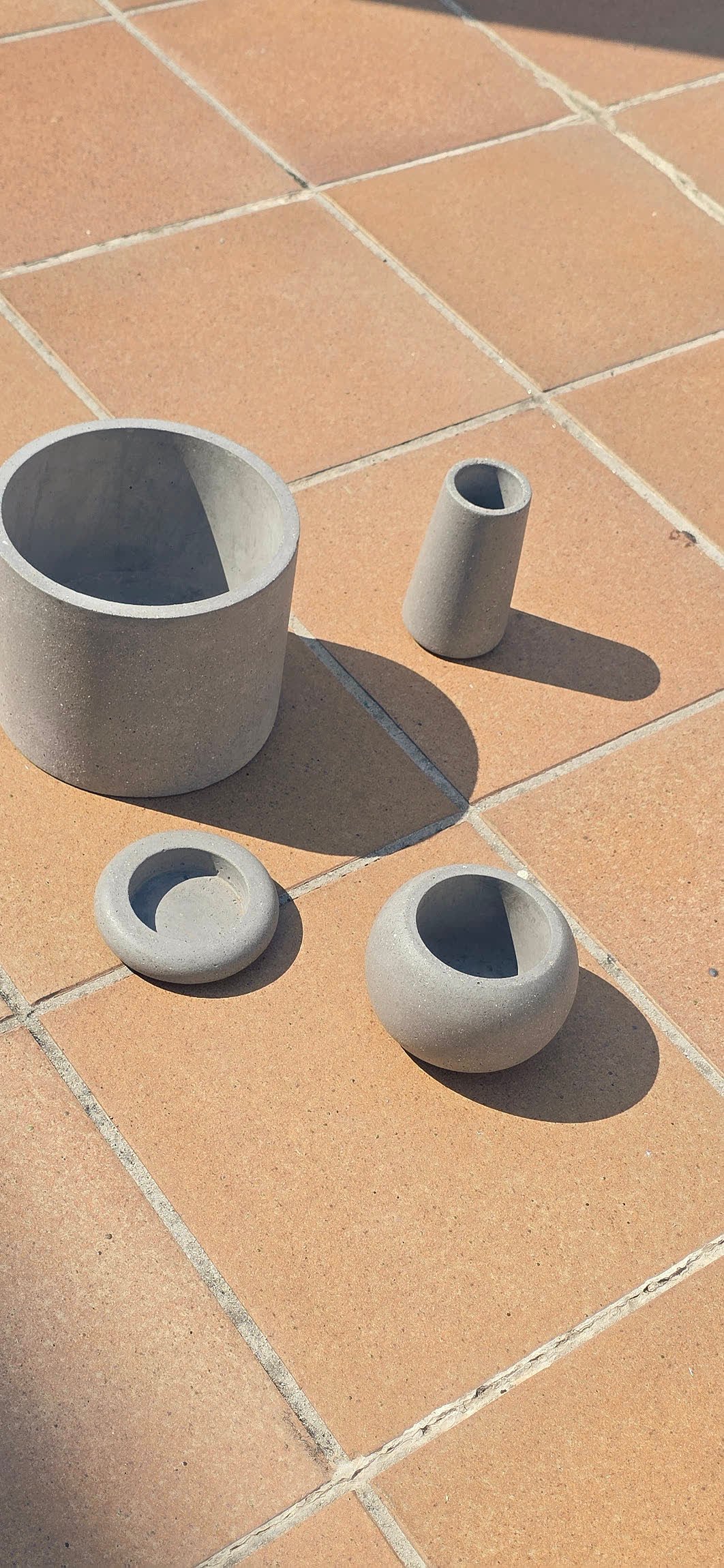 Pack de cuatro piezas de cemento gris natural: macetero, florero, portavelas esfera y portavelas anilla